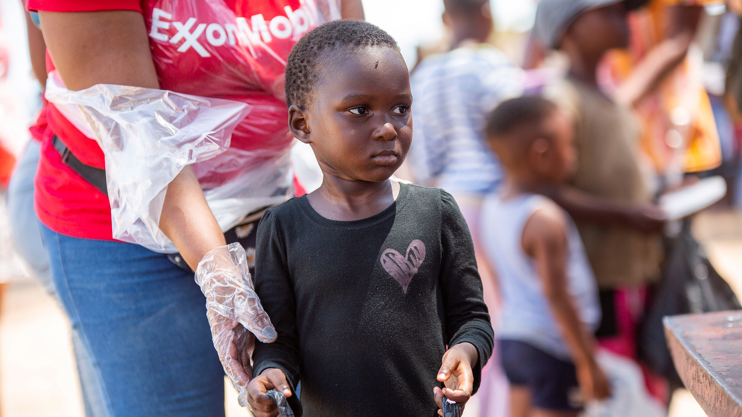 Os voluntários da ExxonMobil cozinharam e distribuíram refeições nutritivas a mais de 150 crianças no Costa do Sol e também distribuíram roupas e brinquedos.
